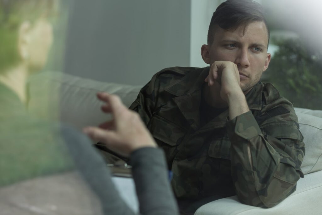Veteran wearing a military cap, looking into the distance, symbolizing PTSD in military personnel